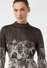 Langärmliges Kleid aus seidig braunem Stoff mit hohem Kragen, das ein cremefarbenes abstraktes Muster aufweist. Glatte Textur, enganliegendes Design und minimales Detail.