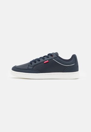Navy blue sneakers made of synthetic material with a white rubber sole, featuring a small red label and perforated side detail.