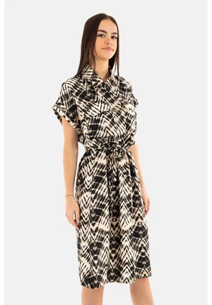 Abito camicia con un motivo a zigzag nero e crema, maniche corte, vita con nastro e chiusura a bottoni sul davanti. Tessuto dalla consistenza liscia.