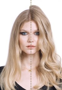 Vrouw met lang blond haar, in het midden gesplitst, met stijl haar aan de linkerzijde en golvend haar aan de rechterzijde, gekleed in een zwarte top en een gouden schelpketting.