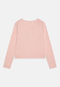 Long-sleeve, cropped top in soft pink fabric featuring a textured pattern and scalloped neckline. Smooth finish and fitted design.