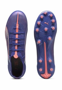 Fialové futbalové kopačky s ružovými akcentmi, štruktúrovaný zvršok, ploché šnúrky a tvarovaná podošva s viacerými kolíkmi pre lepšiu trakciu.