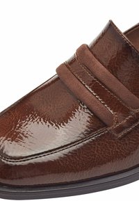Mocassini marroni in pelle lucida e texturizzata con doppie cinghie in suede. Presentano una punta arrotondata e dettagli cuciti sulle cuciture.