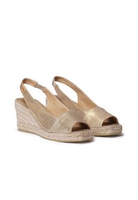 Goldene Keilabsatzsandalen mit offenen Zehen, Obermaterial aus strukturiertem Stoff, juteumwickeltem Absatz und elastischem Fersenriemen für einen sicheren Sitz.