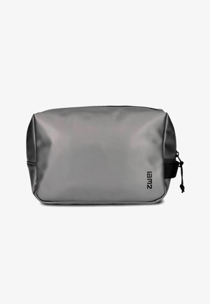 Rechteckige graue Kulturtasche mit schwarzem Reißverschluss und kleinem schwarzem Seitengriff, auf der Vorderseite unten rechts mit dem "iam2"-Logo versehen.