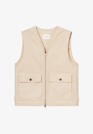 Smėlinės spalvos be rankovių liemenė su priekinėje dalyje esančiu užtrauktuku, dvi didelėmis kišenėmis su sagomis ir maža krūtinės įsiūta kišene, pagaminta iš medvilninės medžiagos.