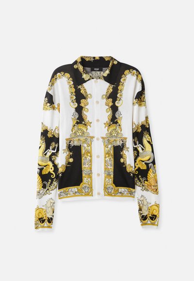 Mustavalkoinen nööpidega särk, millel on kuldsed barokkmustrid, keerukad kujundid merisiilikute, merineid ja dekoratiivsete riistade detailidega.