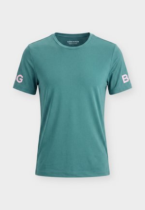 T-shirt à manches courtes couleur sarcelle avec un col rond, un "B" rose sur la manche droite et un "G" sur la manche gauche, tissu lisse, sans autres motifs visibles.