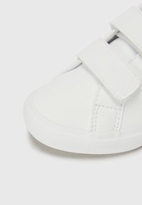 Weiße Sneaker aus glattem Synthetikmaterial mit zwei Klettverschlüssen, abgerundeter Spitze und strukturiertem Gummisohle.