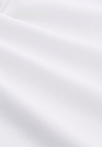Weißer Stoff mit einer feinen gerippten Textur, der in sanften Falten fällt. Die Oberfläche erscheint glatt und gleichmäßig und präsentiert einen klaren, monochromen Look.