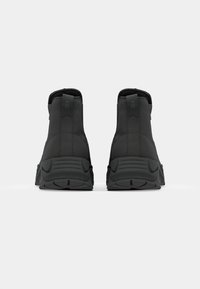 Black high-top sneakers with a smooth finish and textured soles, displayed from the back against a plain white background.
