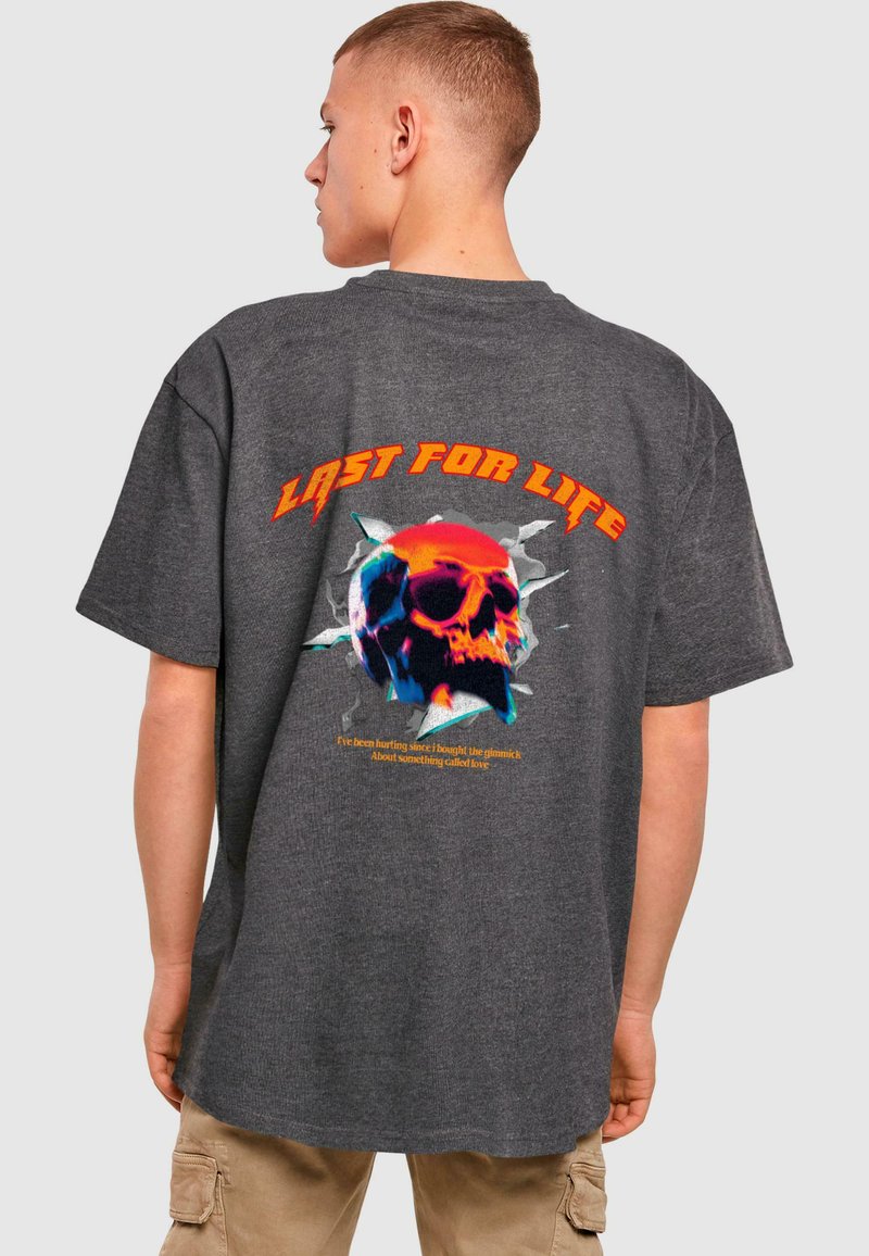Tmavě šedé oversized tričko s barevným potiskem lebky a textem "LAST FOR LIFE" na zadní straně, vyrobené z texturované látky.
