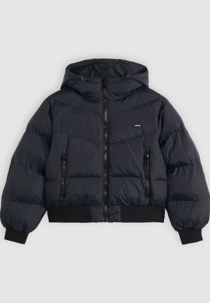 Chaqueta acolchada en azul marino oscuro, con capucha, cierre con cremallera, dos bolsillos laterales con cremallera y puños y dobladillo elásticos para mayor comodidad.