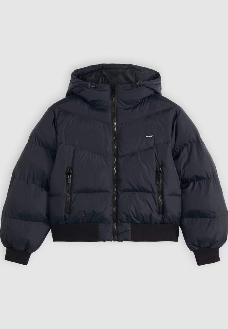 Veste matelassée en bleu marine foncé, dotée d'une capuche, d'une fermeture éclair, de deux poches latérales zippées, et de poignets et d'un ourlet élastiques pour un confort supplémentaire.