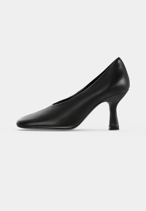 Escarpin en cuir noir à bout pointu et talon fin de hauteur moyenne, présenté de profil sur un fond clair.