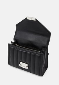 Musta nahkakäsilaukku, jossa on tikattu pinta, hopeiset varusteet ja vetoketjullinen osasto. Avoin läppämuotoilu, jonka sisätila on näkyvissä.