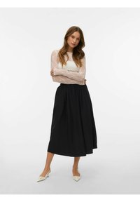 Bel zgornji del z dolgimi rokavi iz čipke s prilegočo korsetno obliko, kombiniran s črno midisečno krilom. Model nosi krem rjave čevlje z ostrimi konicami. Preprost, eleganten dizajn.