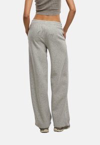 Pantaloni da tuta in cotone grigio con una vestibilità rilassata, caratterizzati da un testo decorativo "Juicy" in strass sul retro. Vita e polsini elasticizzati.