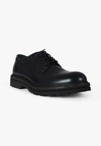 Scarpe derby in pelle nera con punta arrotondata, design con lacci e suola spessa in gomma. Presentano cuciture lungo il bordo e una finitura liscia.