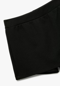 Schwarze Badehorts aus strukturiertem Gewebe mit elastischem Bund und ohne sichtbare Beschläge oder Akzente. Glattes, schlichtes Design.