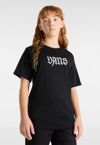Zwarte katoenen t-shirt met korte mouwen, met een witte gestileerde "VANS" logo over de borst. Eenvoudig, klassiek ontwerp.