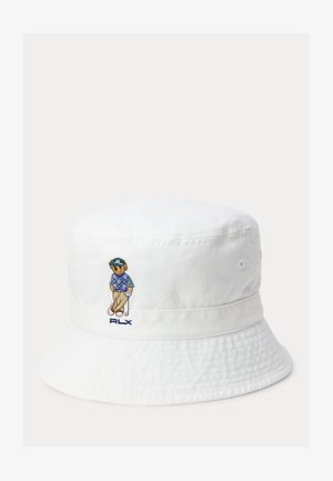 Bob blanc avec un golfeur brodé portant une chemise bleue et un pantalon beige, tenant un club de golf, avec le texte "RLX" en dessous.