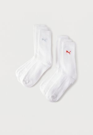 Dvi poros baltų kojinių su ribinėmis rankovėmis, viena pora su šviesiai mėlynu Puma logotipu, kita pora su raudonu Puma logotipu.