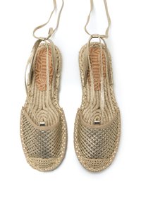 Espadrilles dorées tissées avec une semelle en corde tressée, présentant un dessus texturé et un lien réglable pour un ajustement sécurisé.