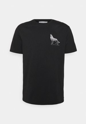 Camiseta negra de manga corta con un gráfico blanco de un lobo y el texto "WALK ALONE" en el lado superior izquierdo del pecho.