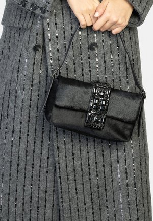 Borsa nera con materiale testurizzato simile a pelliccia, decorata con una chiusura a gemma nera decorativa. Piccola dimensione con una sottile tracolla.
