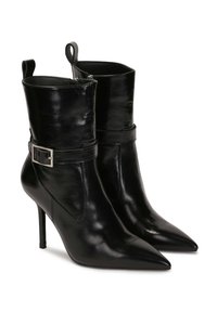 Botines de cuero negro hasta el tobillo con punta afilada, alto tacón de aguja, cierre lateral con cremallera y una hebilla decorativa en la correa.