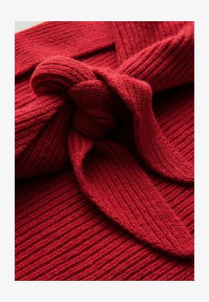 Roter Strickstoff mit gerippter Textur, der ein geknotetes Design aufweist. Das Material wirkt weich und dick, geeignet für Wärme.