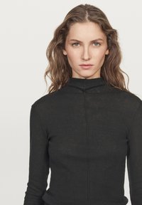 Black long-sleeve top featuring a high collar, a slim fit, and a central seam detail on the front. The fabric appears soft and slightly sheer.