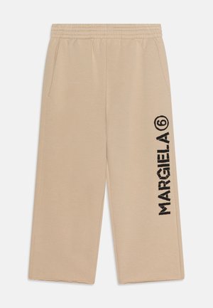 Beige bukser med vide ben, elastik i taljen, sidelommer og sort lodret tekst "MARGIELA 6" på højre ben.