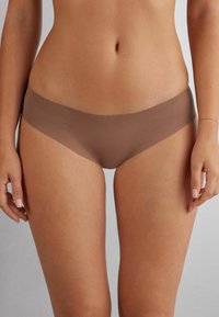Sous-vêtements hipster marron sans couture avec une texture douce. La ceinture est large et repose confortablement sur les hanches. Design minimal sans coutures visibles.