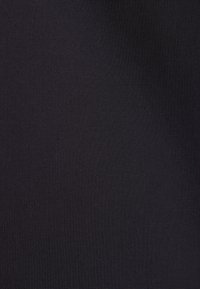 Texture de tissu noir uni avec un motif de tissage fin, montrant de subtiles variations dans les nuances et la structure du tissu.