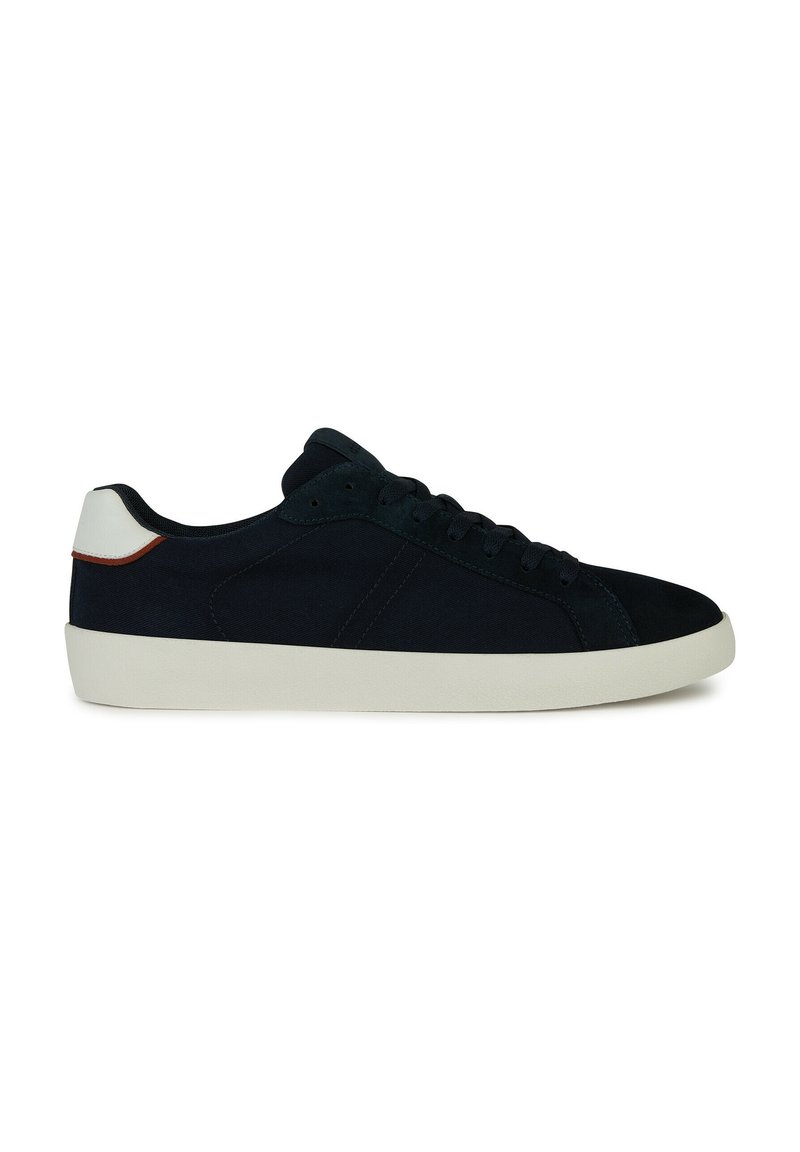 Sneaker in suede blu navy con accento bianco sul tallone e suola in gomma. Presenta una punta arrotondata e un design classico con lacci.