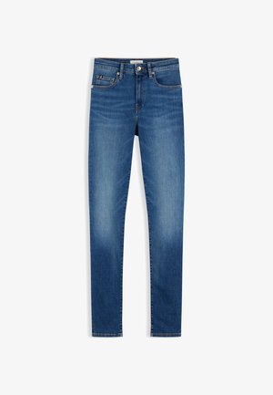 Kék karcsúsított farmerek, öt zsebes kialakítással és enyhe kifakulással a combokon és térdeken, gombos és cipzáras záródással deréknál.