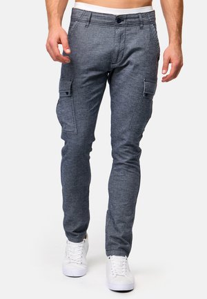 Graue Cargo-Hosen aus strukturiertem Stoff mit zwei Seitentaschen, Knopfverschluss und Slim Fit. Kombiniert mit weißen Sneakers.