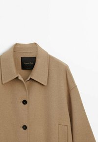 Beige wool coat with a flat collar, two buttons, and side pocket. Soft texture and clean lines, suitable for layering. Brand label visible.