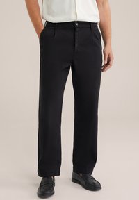 Los pantalones de algodón negros presentan un diseño de pierna recta, cierre de botón y bolsillos laterales, con una textura suave y mate.