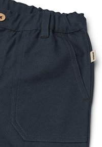 Shorts bleu foncé en tissu texturé avec une taille élastiquée, dotés d'une fermeture à bouton et de poches latérales avec des coutures visibles.