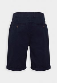 Shorts homme bleu marine avec ourlets retournés, passants de ceinture et deux poches arrière fermées par des boutons.