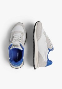 Zapatillas deportivas para hombre con parte superior de cuero blanco, acentos de ante gris y detalles de goma azul. Presenta una suela negra texturizada.
