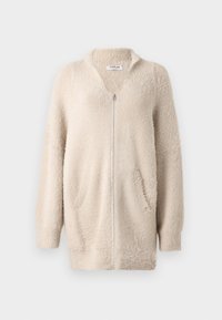 Beige ritsvest gemaakt van zacht, pluizig materiaal. Heeft een v-hals, twee voorzakken en lange mouwen. Eenvoudig, textuur ontwerp.