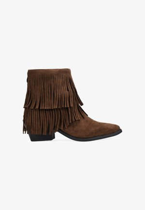 Botas de tobillo de ante marrón con flecos en capas, punta afilada, tacón apilado y suela de goma negra.