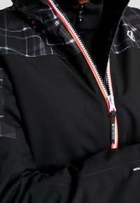 Schwarze Jacke mit einem Reißverschluss in Orange und Silber. Sie verfügt über ein kariertes Design auf den Schultern und eine elegante, glatte Textur. Markenlabel sichtbar.