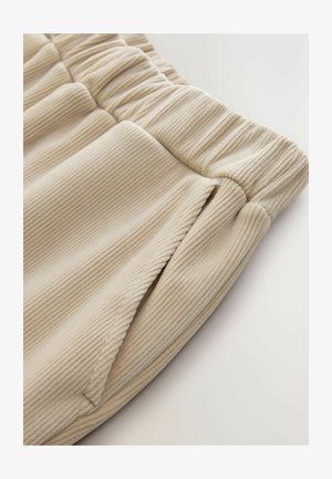 Beige, bordázott anyagú nadrág, rugalmas derékkal és oldalsó zsebekkel, puha tapintású és laza szabású.