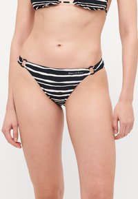 Dno bikinija na crno-bijele pruge s okruglim detaljima sa strane. Izrađeno od glatkog materijala, s logotipom blizu bokova.