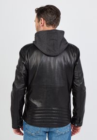 Sort læderjakke med grå hætteforing, med en tætsiddende pasform, ribbet detaljering ved kanten og knapdetaljer på ærmerne.